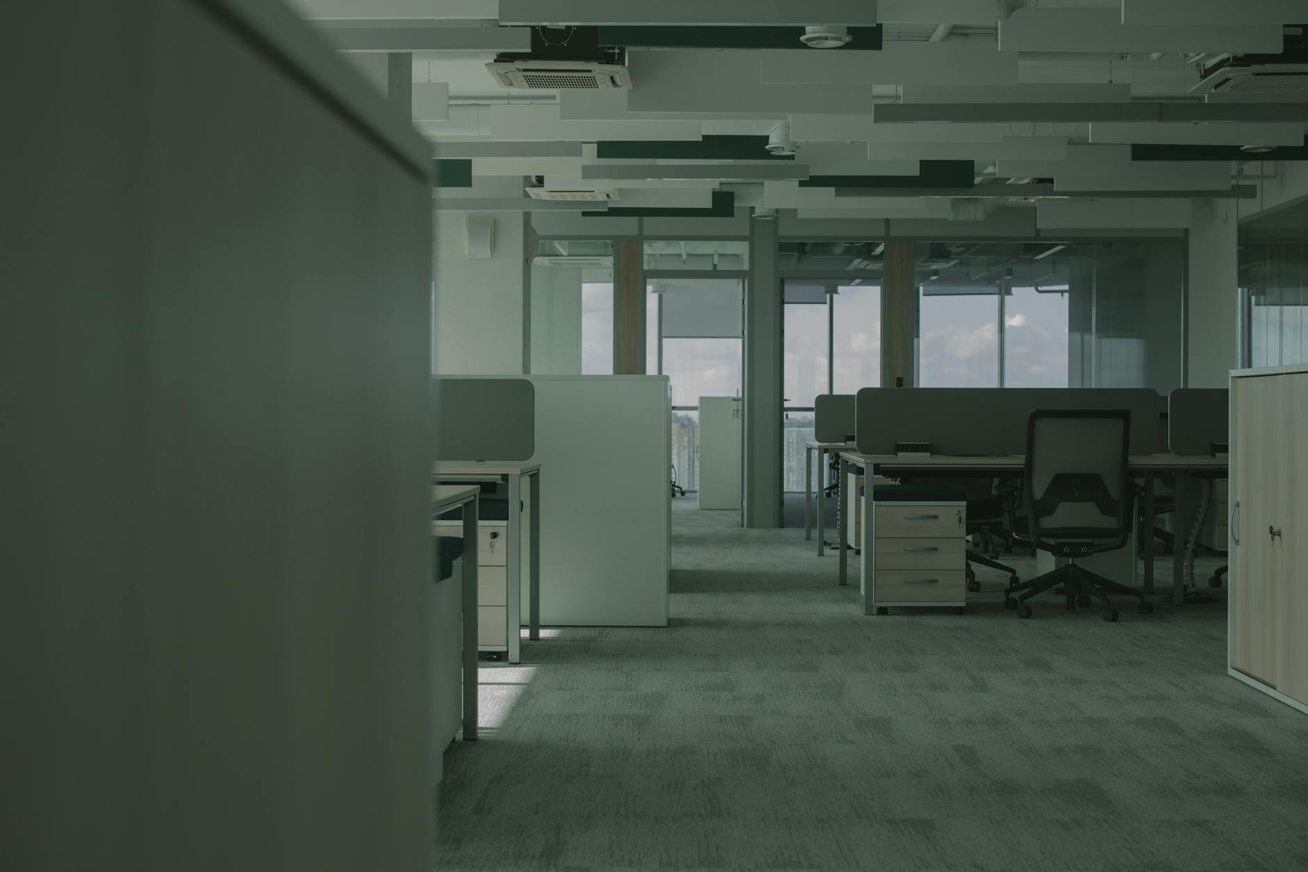 Empty modern office building interior showing vacant workspaces and desks
