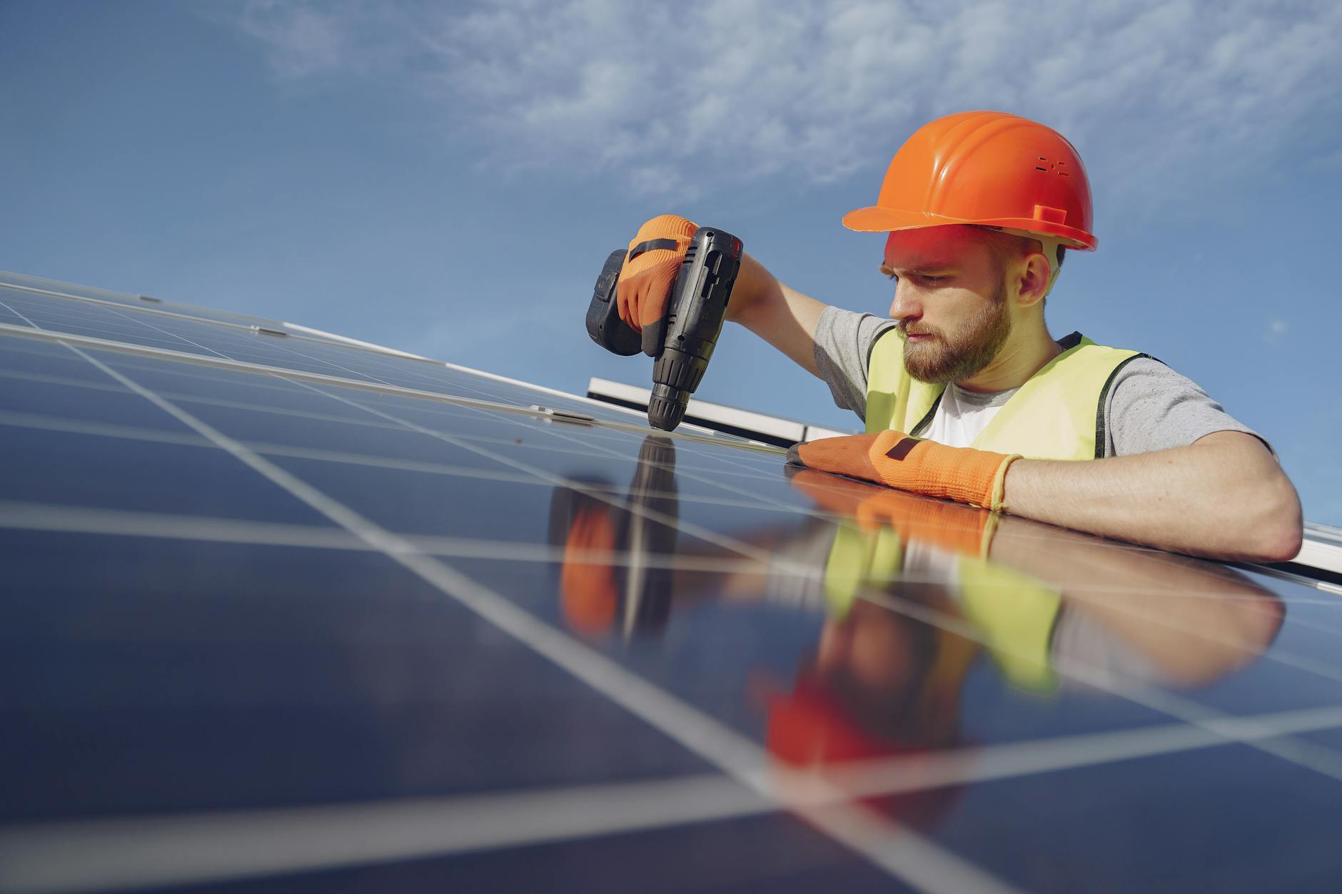 Solar panel installation on residential roof with blue sky background