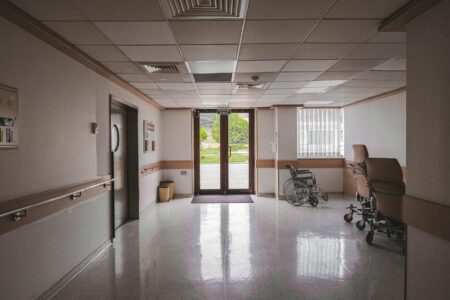 Empty hospital hallway with medical equipment and nursing station