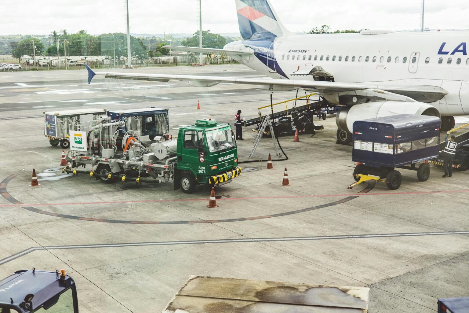Workers loading cargo containers into the belly of a commercial aircraft at an airport terminal