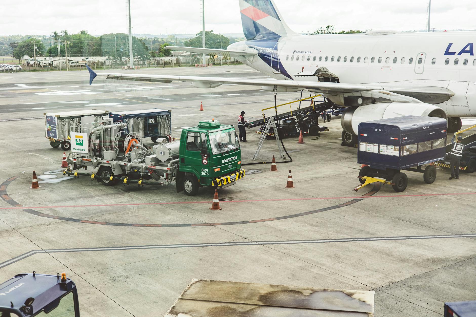 Workers loading cargo containers into the belly of a commercial aircraft at an airport terminal