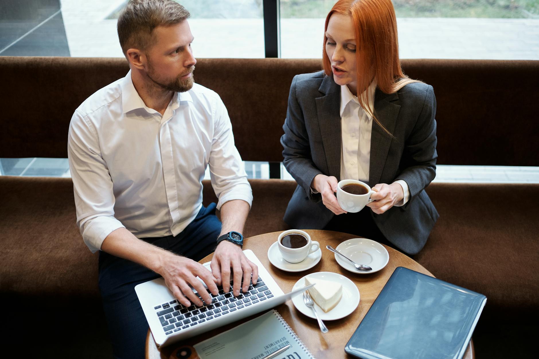 Person working on laptop with coffee cup, representing side hustle work
