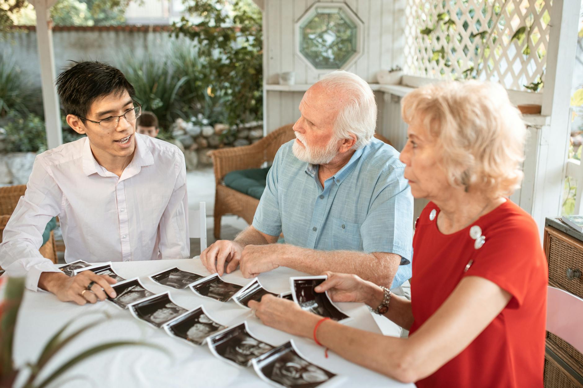 Family discussing financial planning around a table with documents and laptops