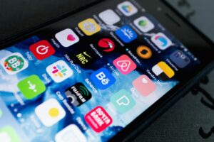 Close-up view of smartphone screen displaying various colorful mobile applications and app icons