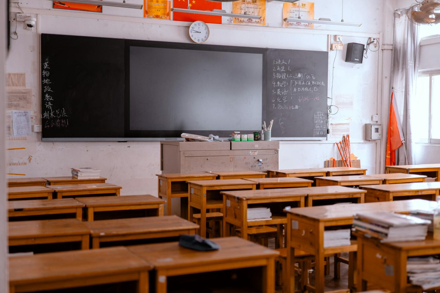 Empty classroom with rows of desks and chairs showing the impact of teacher shortages