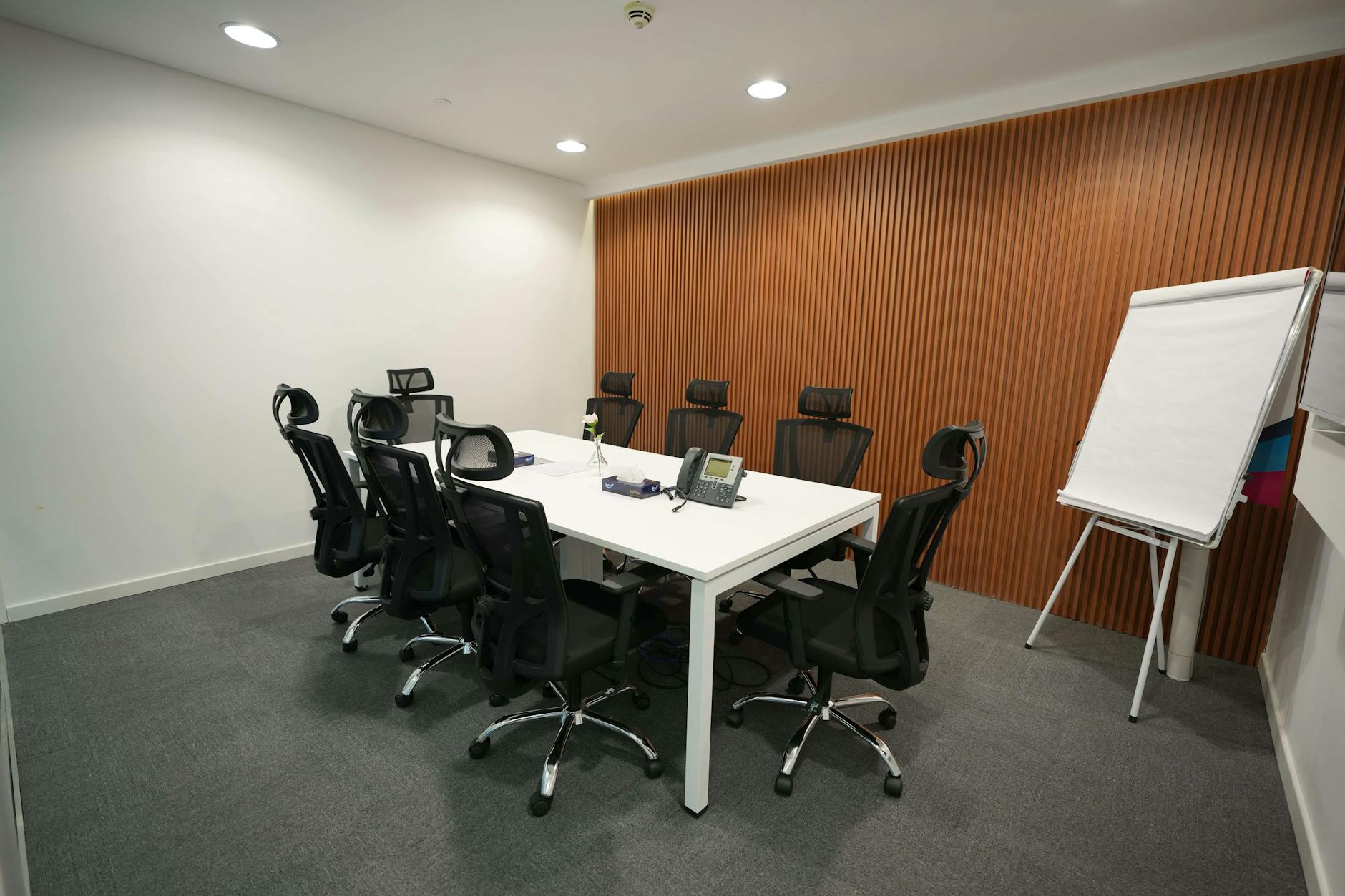 Modern corporate meeting room with presentation screen showing business charts and graphs