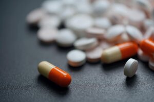 Close-up of prescription medication bottles and pills on pharmacy counter