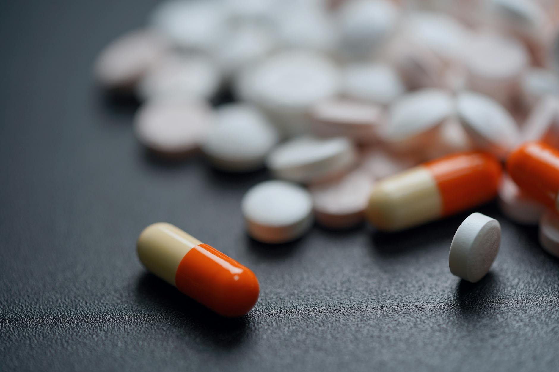 Close-up of prescription medication bottles and pills on pharmacy counter
