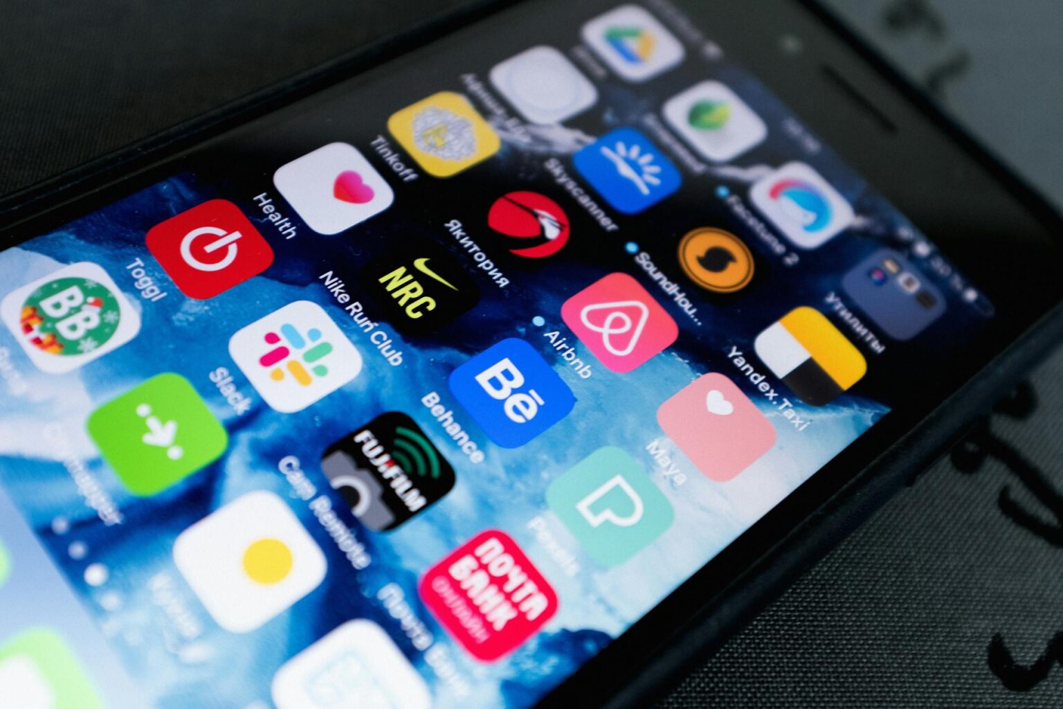 Person using smartphone to review property investment app showing real estate listings and portfolio performance