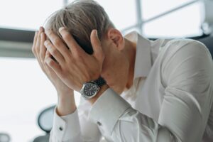 Business professional looking stressed while working at desk in modern office environment