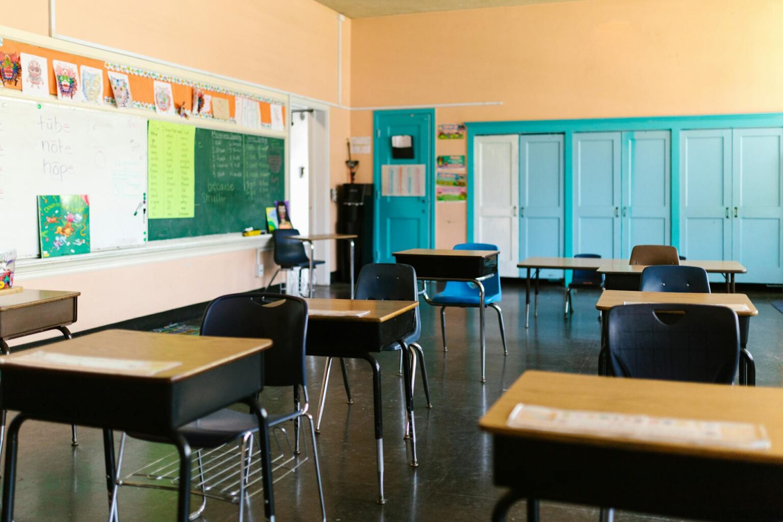 The Economic Impact of America’s Teacher Shortage on Local Housing Markets Empty classroom with desks and chairs arranged but no students or teacher present
