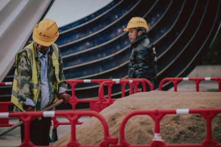 Construction workers in hard hats and safety vests working on a building site