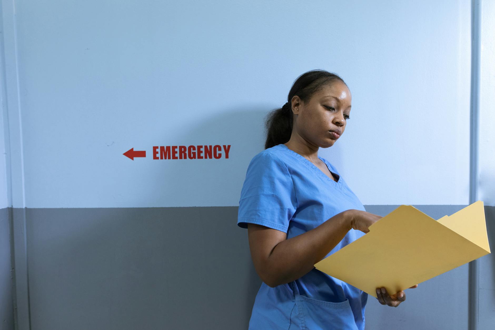 Healthcare professional in scrubs working at computer in medical facility