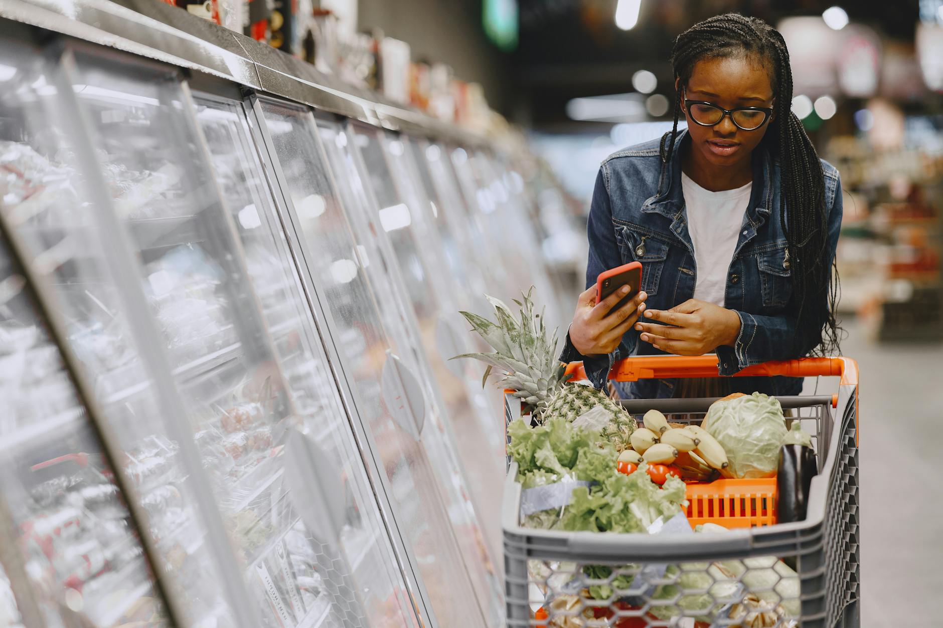 Shopping cart filled with groceries in store aisle showing retail competition