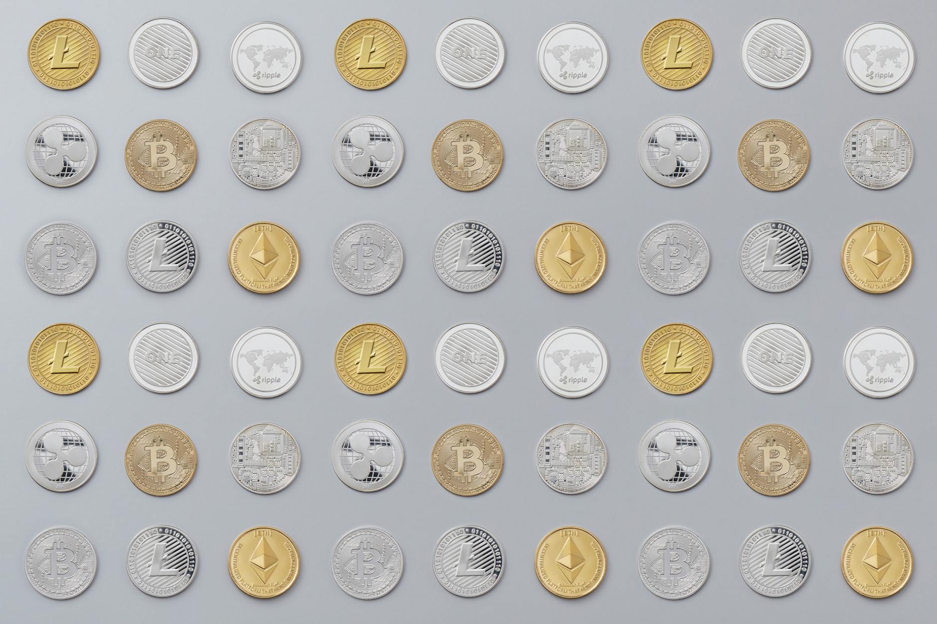 Various cryptocurrency coins including Bitcoin and Ethereum arranged on a table representing digital asset investments