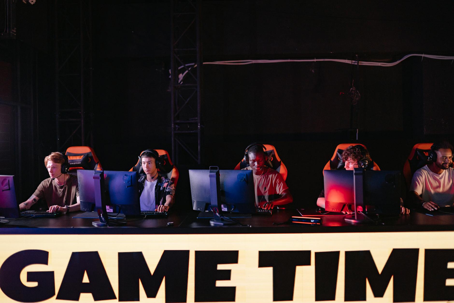 Professional esports tournament venue with large screens and competitive gaming atmosphere