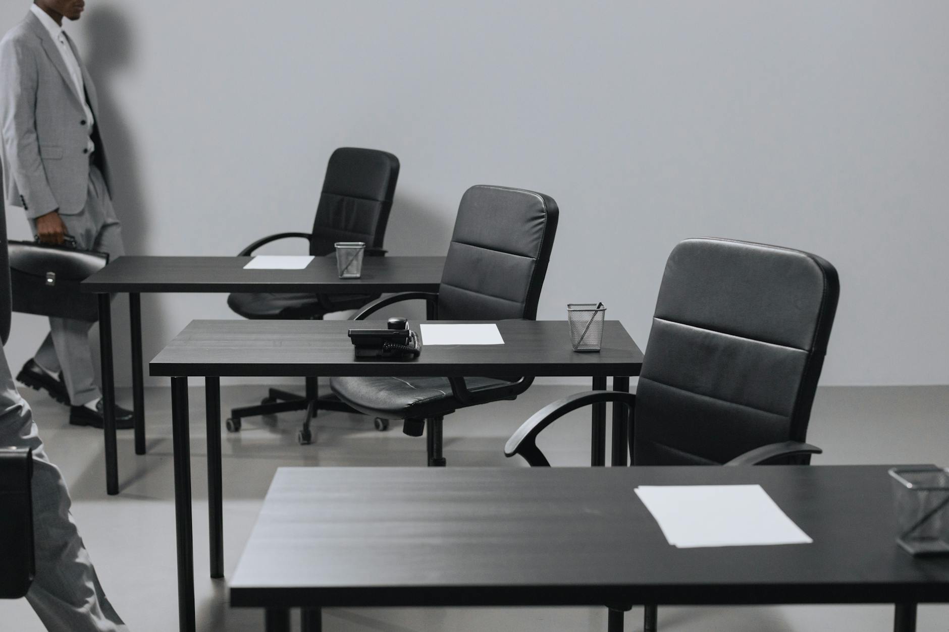 Empty office chairs around conference table representing employee turnover and vacant positions