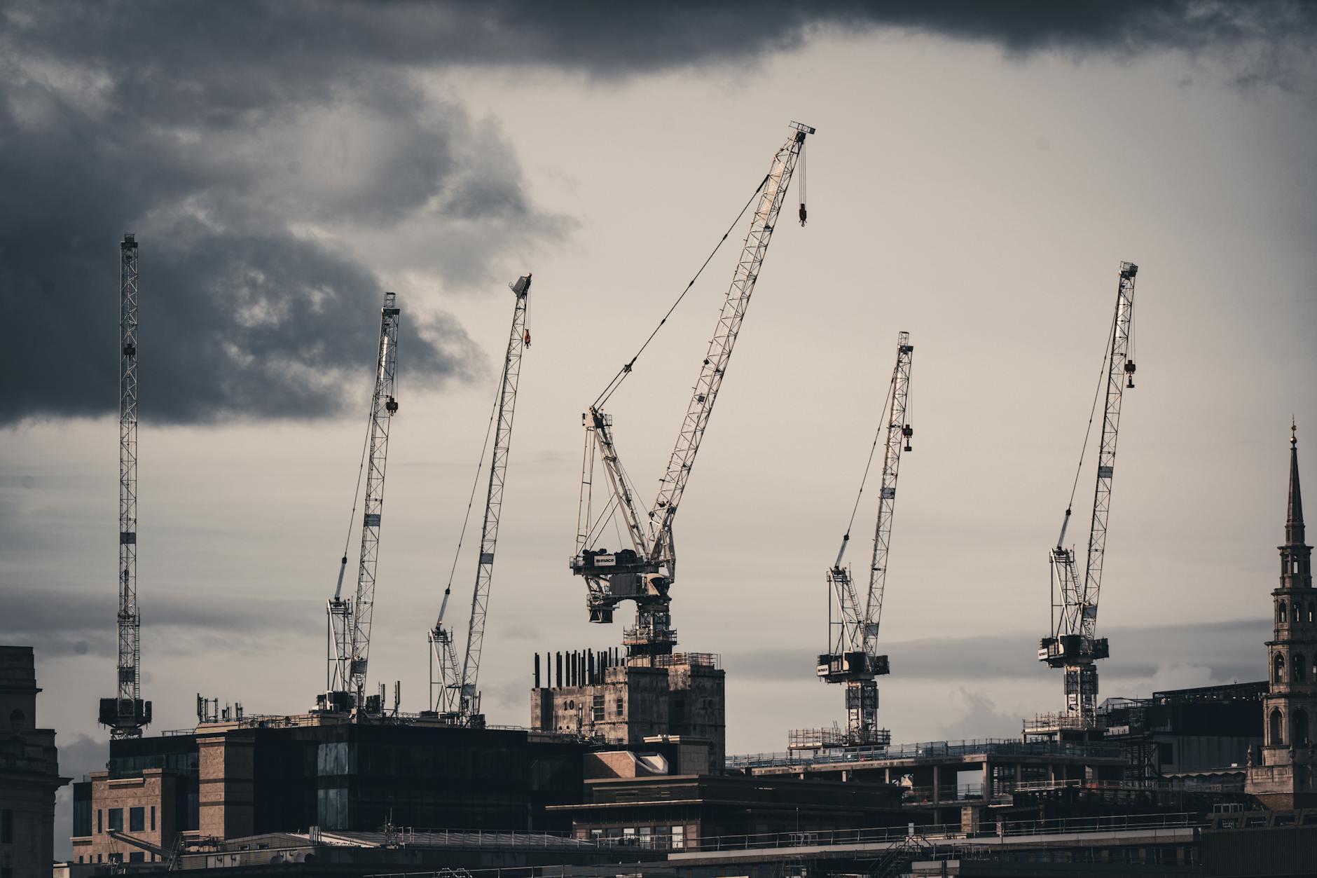 Urban skyline with construction cranes showing ongoing development and adaptation in commercial real estate markets