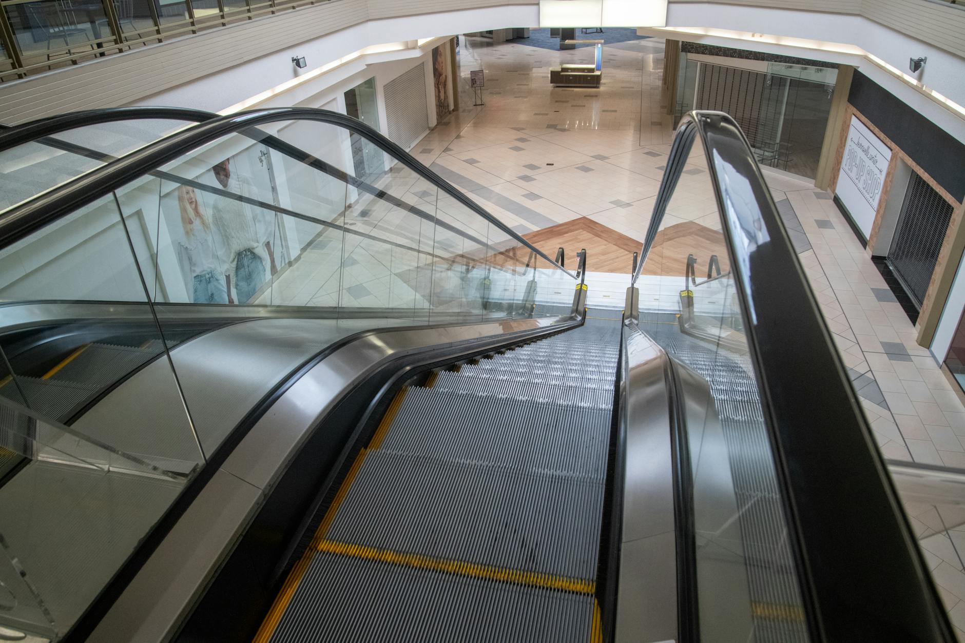 Empty retail space interior with bare shelves, illustrating the impact of business closures on communities