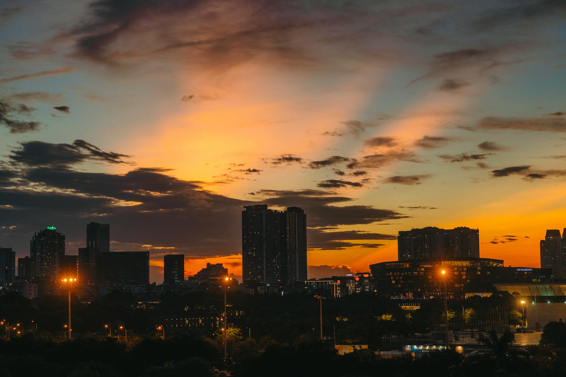 Modern city skyline with infrastructure and transportation networks visible at sunset