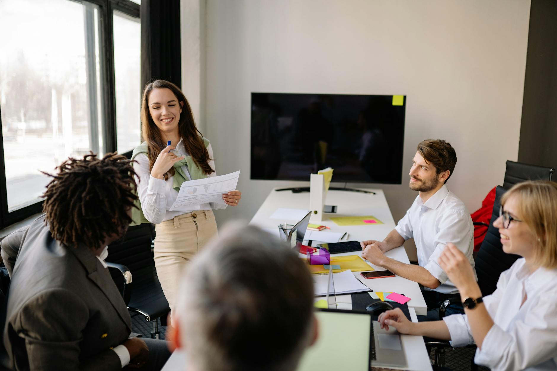 Diverse business team having discussion around conference table in modern office