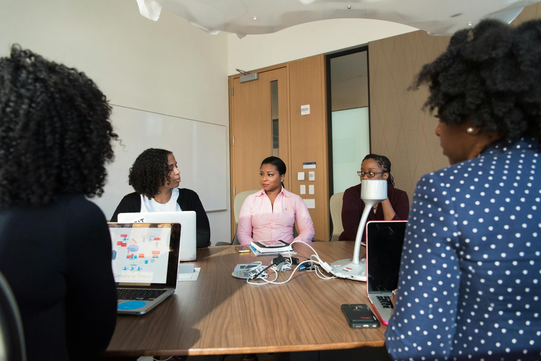 Business professionals analyzing data and charts on digital screens in modern office