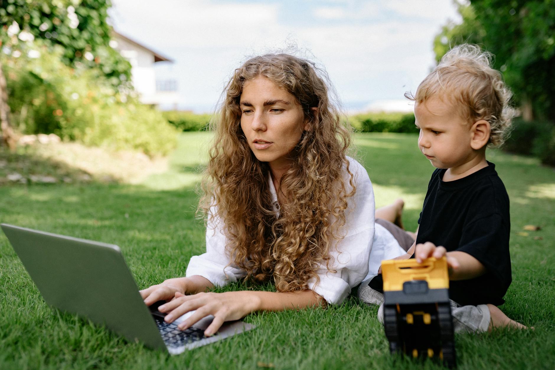 Professional woman working on laptop while managing family responsibilities at home