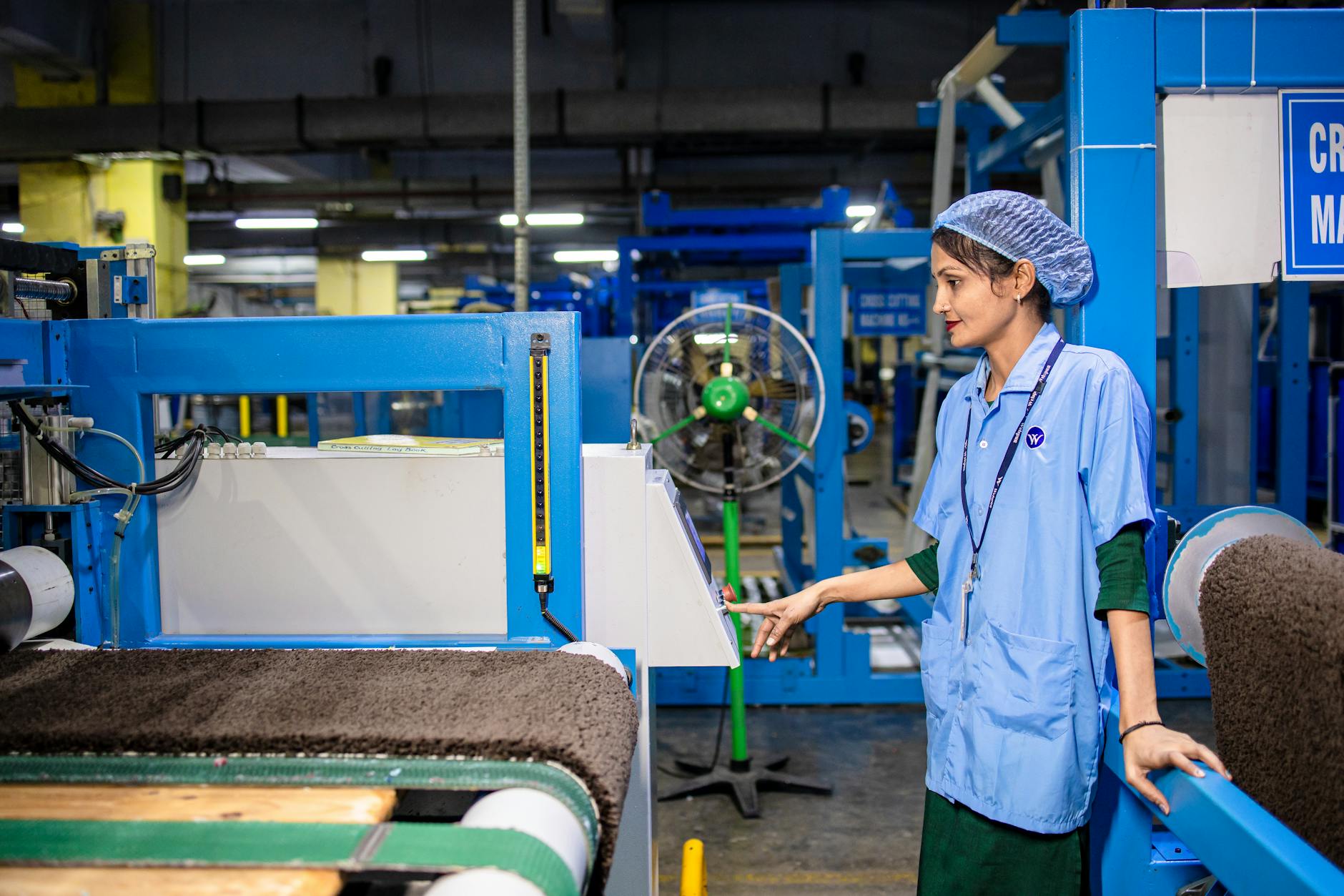 Manufacturing worker operating industrial machinery in modern factory setting
