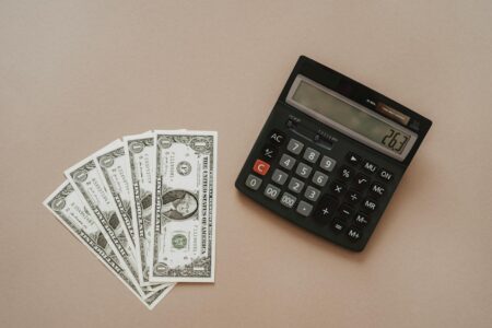 Calculator and cash showing financial calculations