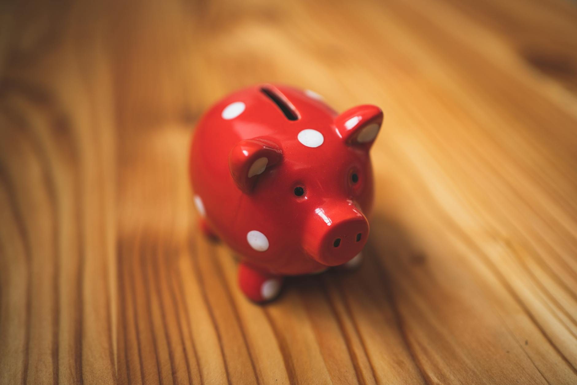 Pink piggy bank on wooden table representing savings