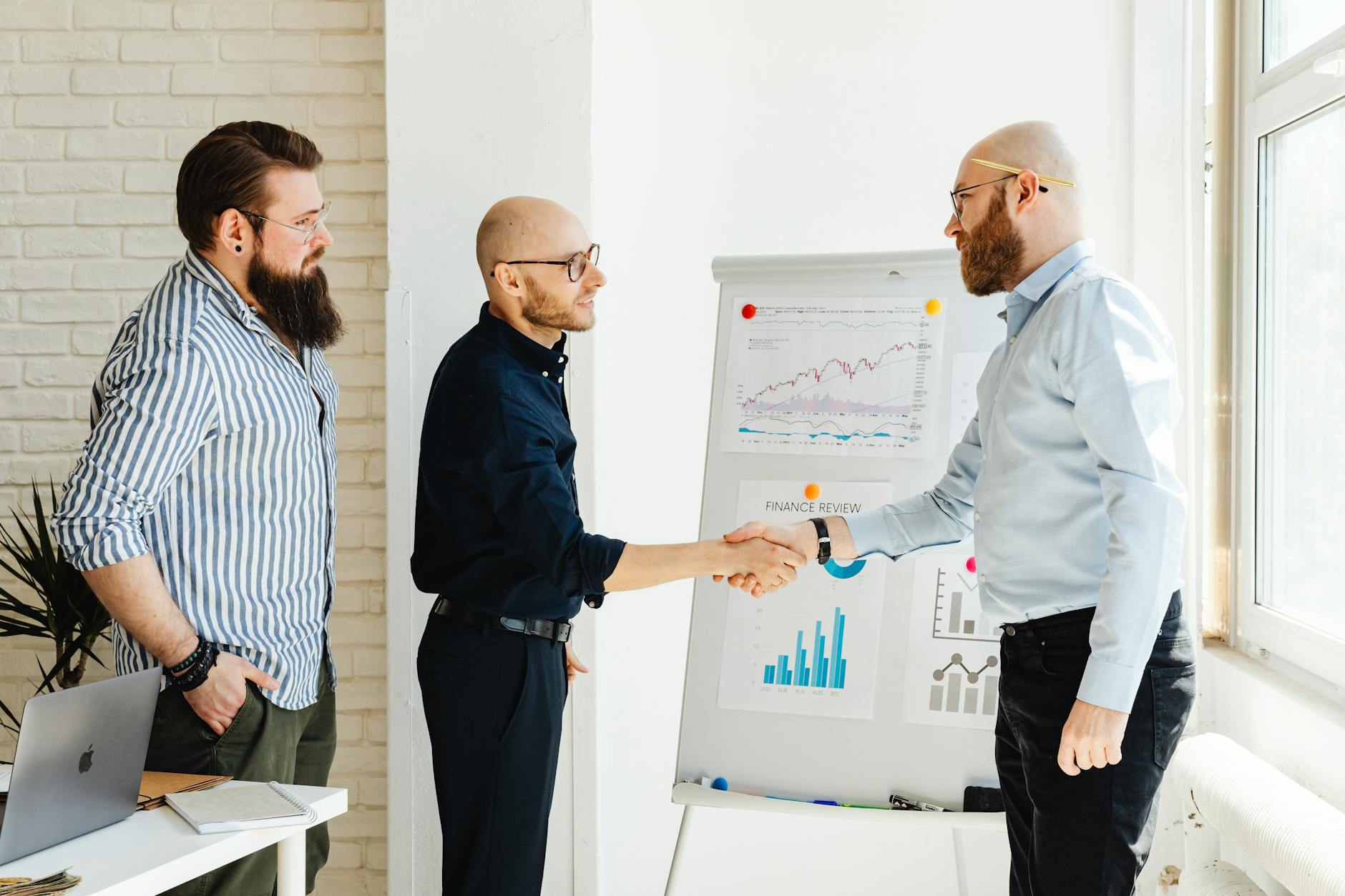 Business professionals shaking hands during acquisition meeting