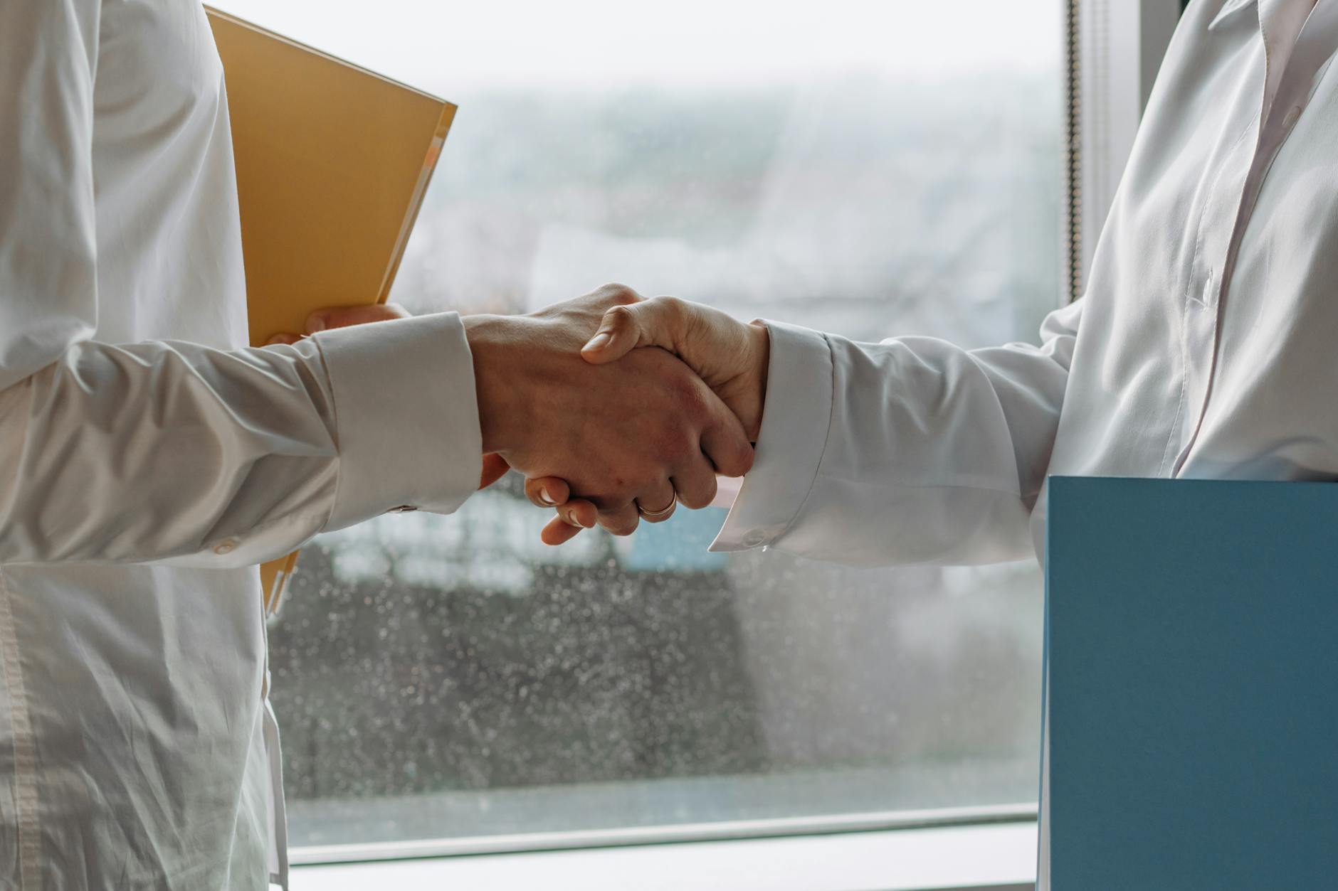 Professional business handshake between executives in corporate office setting