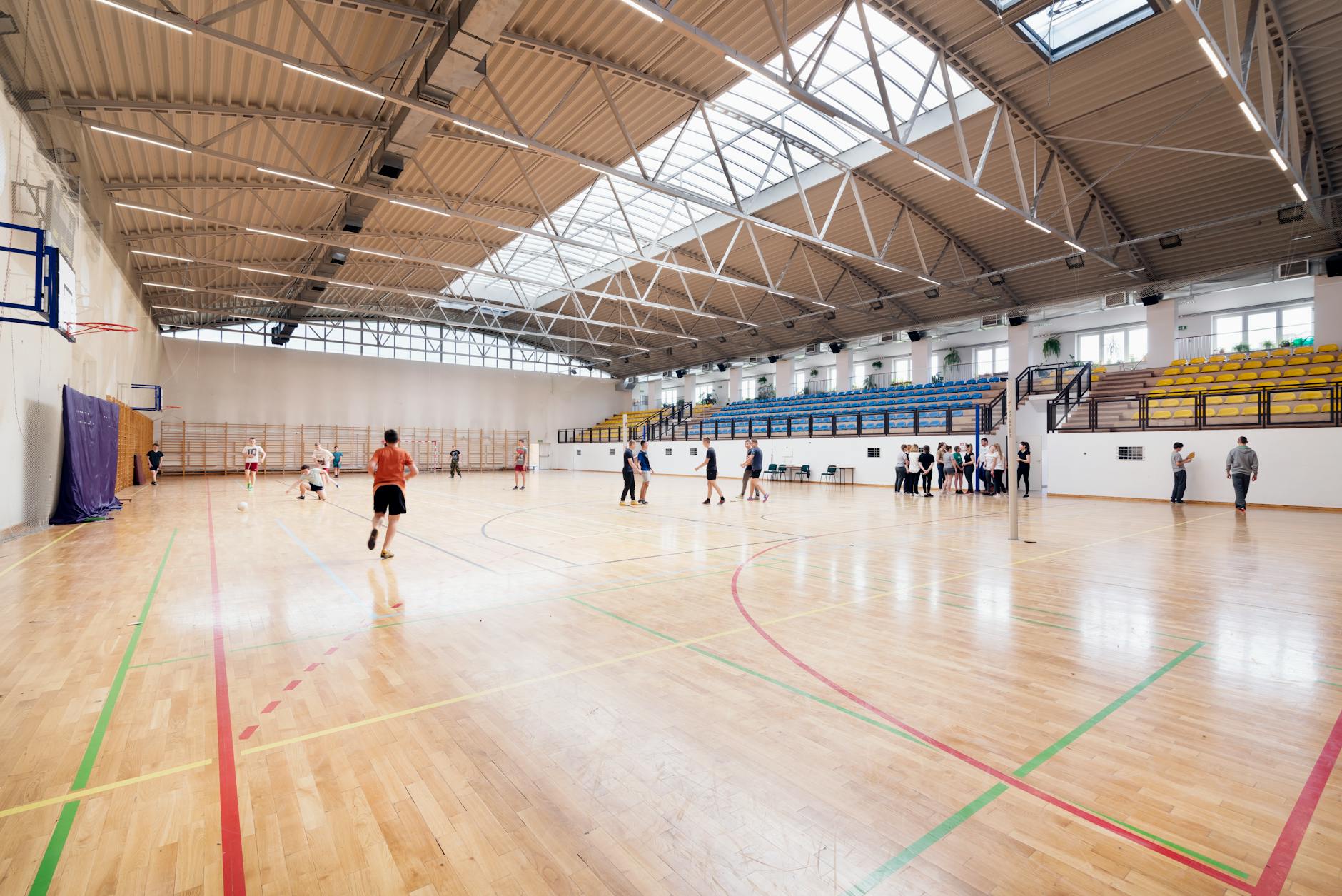 Empty basketball arena with bright court lighting and stadium seating