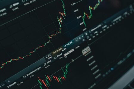 Multiple computer screens displaying Asian stock market data and trading charts