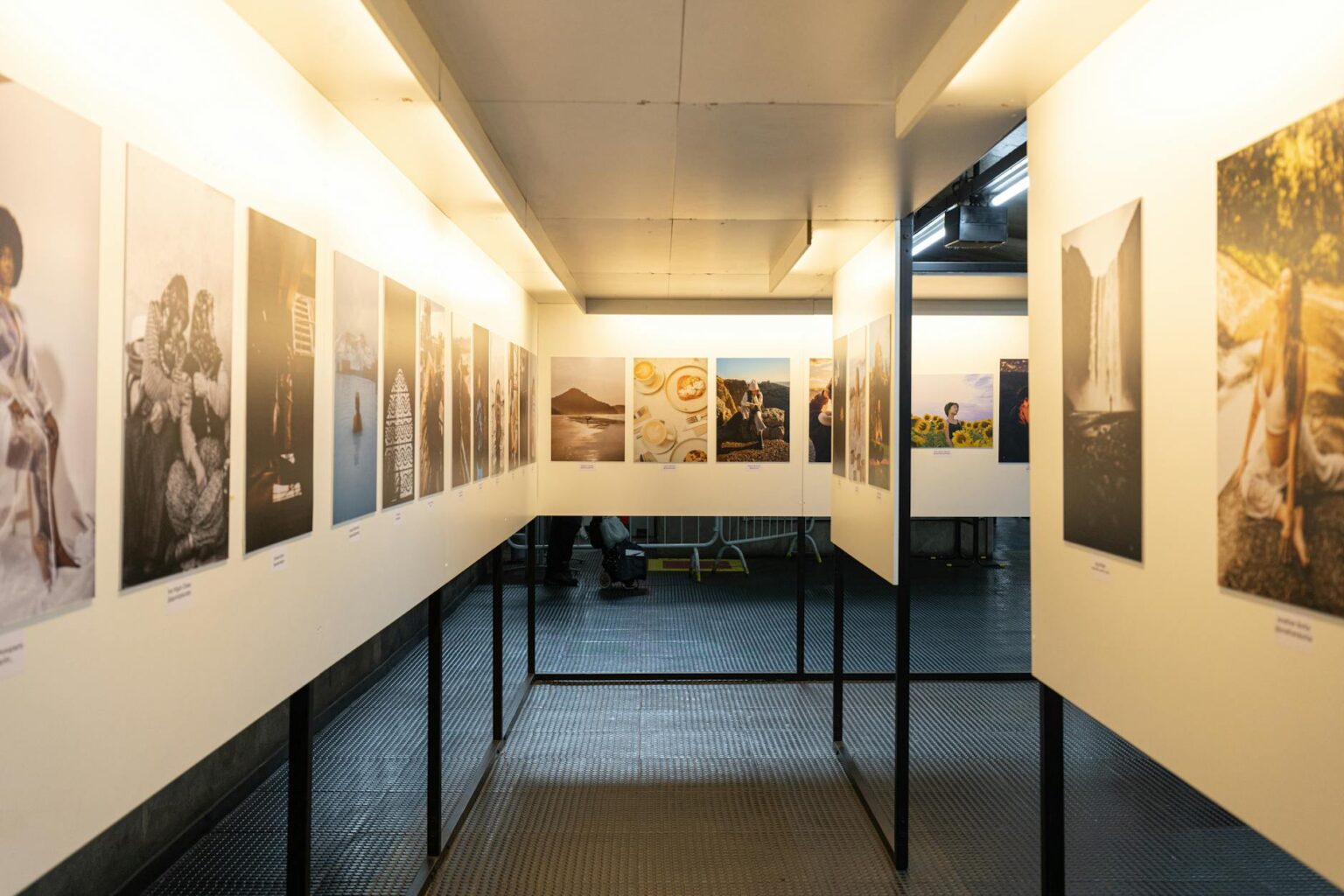 Modern art gallery with visitors viewing paintings on white walls