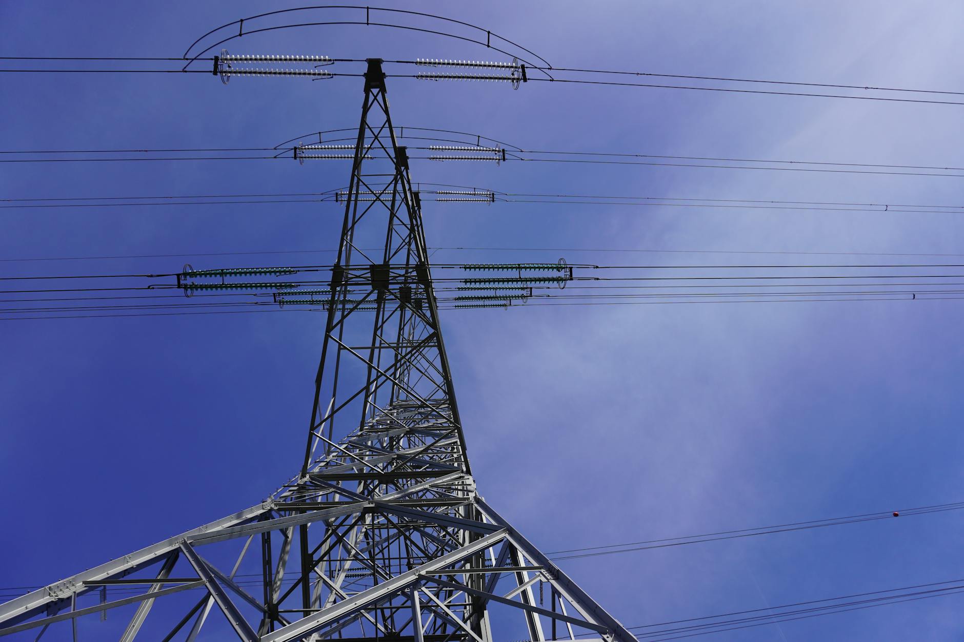 High voltage transmission lines against blue sky