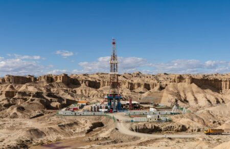 Oil drilling equipment against sky representing energy market tensions