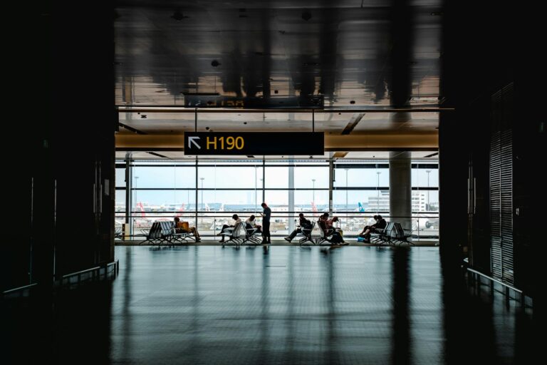 Travelers walking through a busy airport terminal during peak travel season