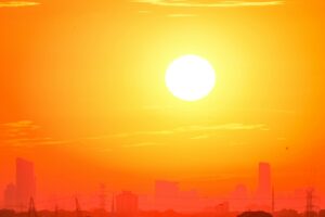 Hazy urban skyline under intense heat with distorted air visible above streets