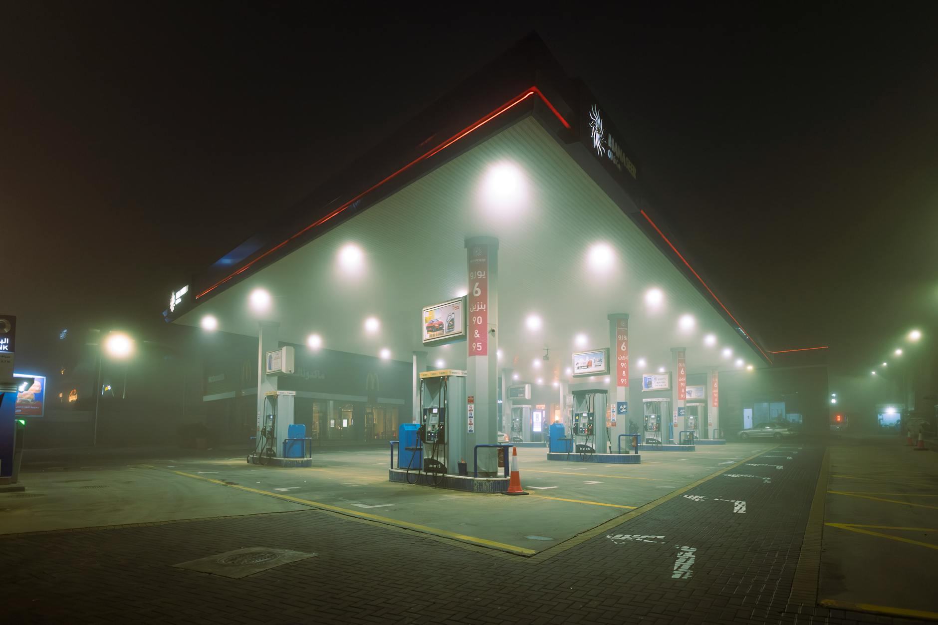 Person refueling car at gas station pump showing price display