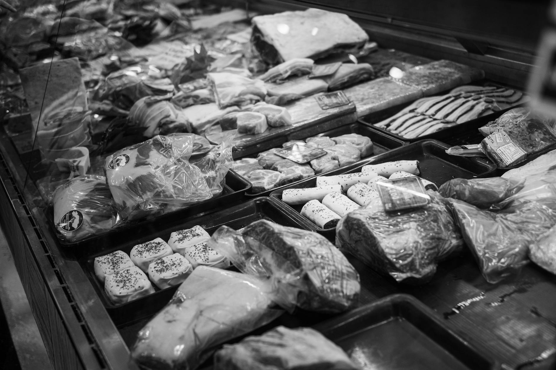 Customer shopping for beef at grocery store meat counter