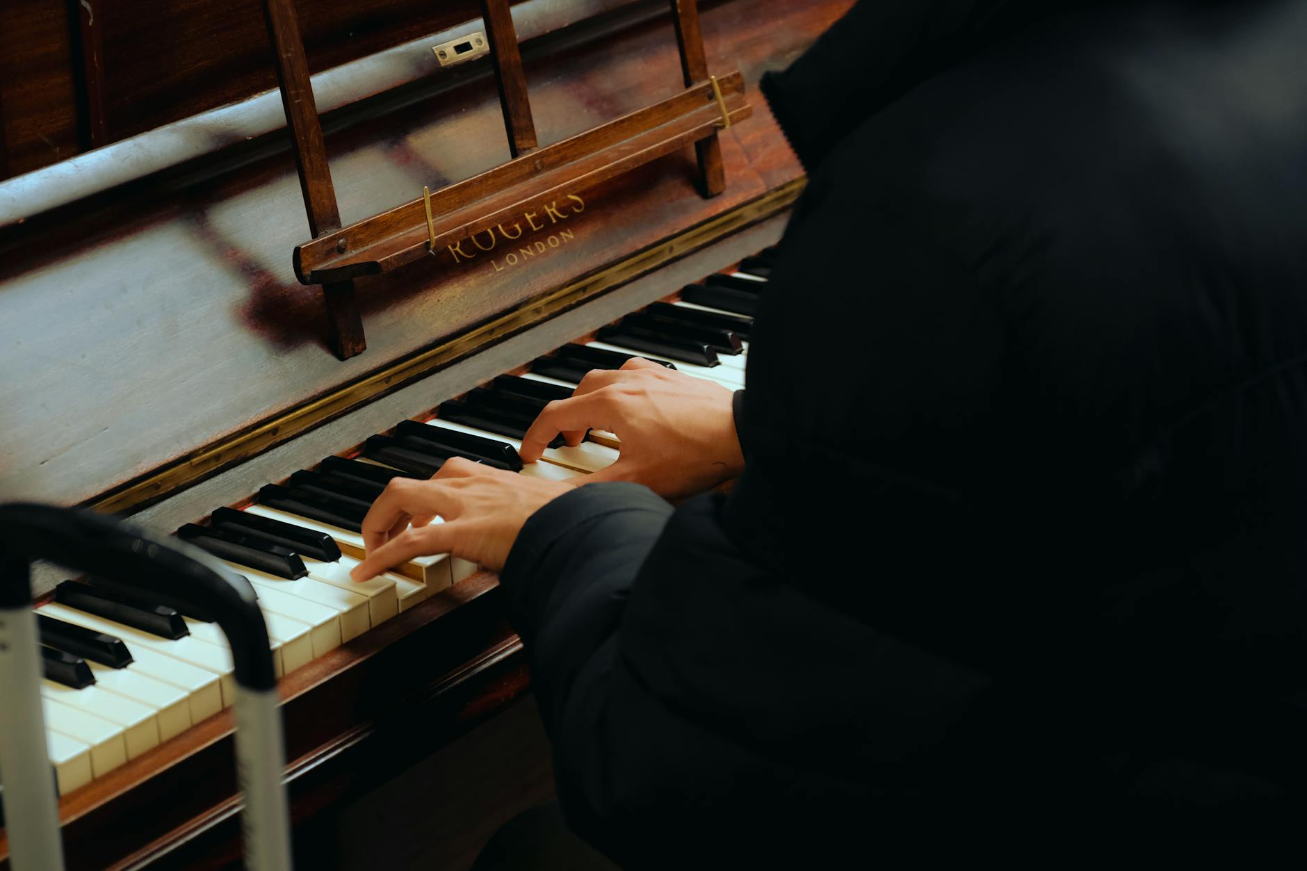 Hands resting near piano keys suggesting physical limitation and music