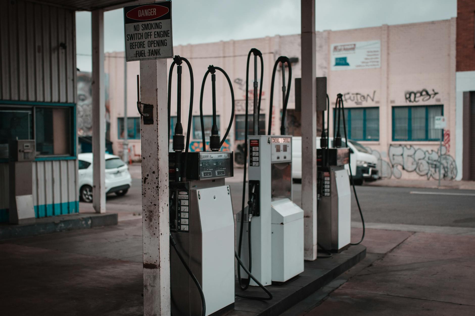 Driver pumping gas at a fuel station as prices rise