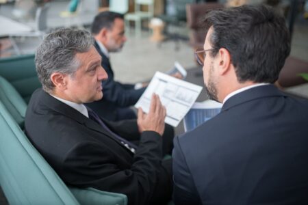 Consultants working at a large corporate office reviewing business strategy documents