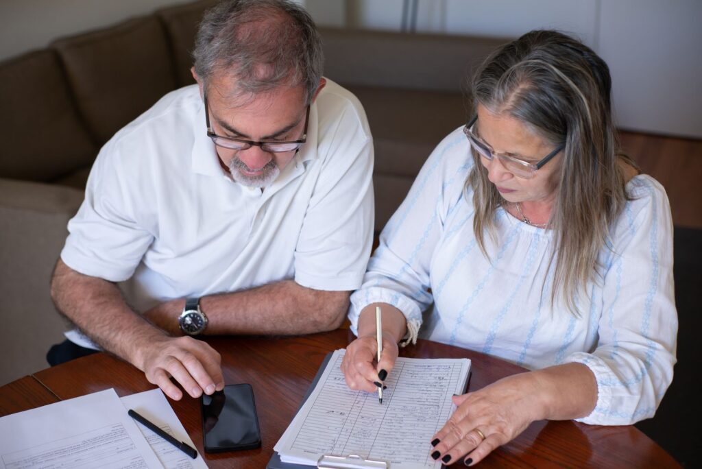 Retired couple reviewing financial documents at a table