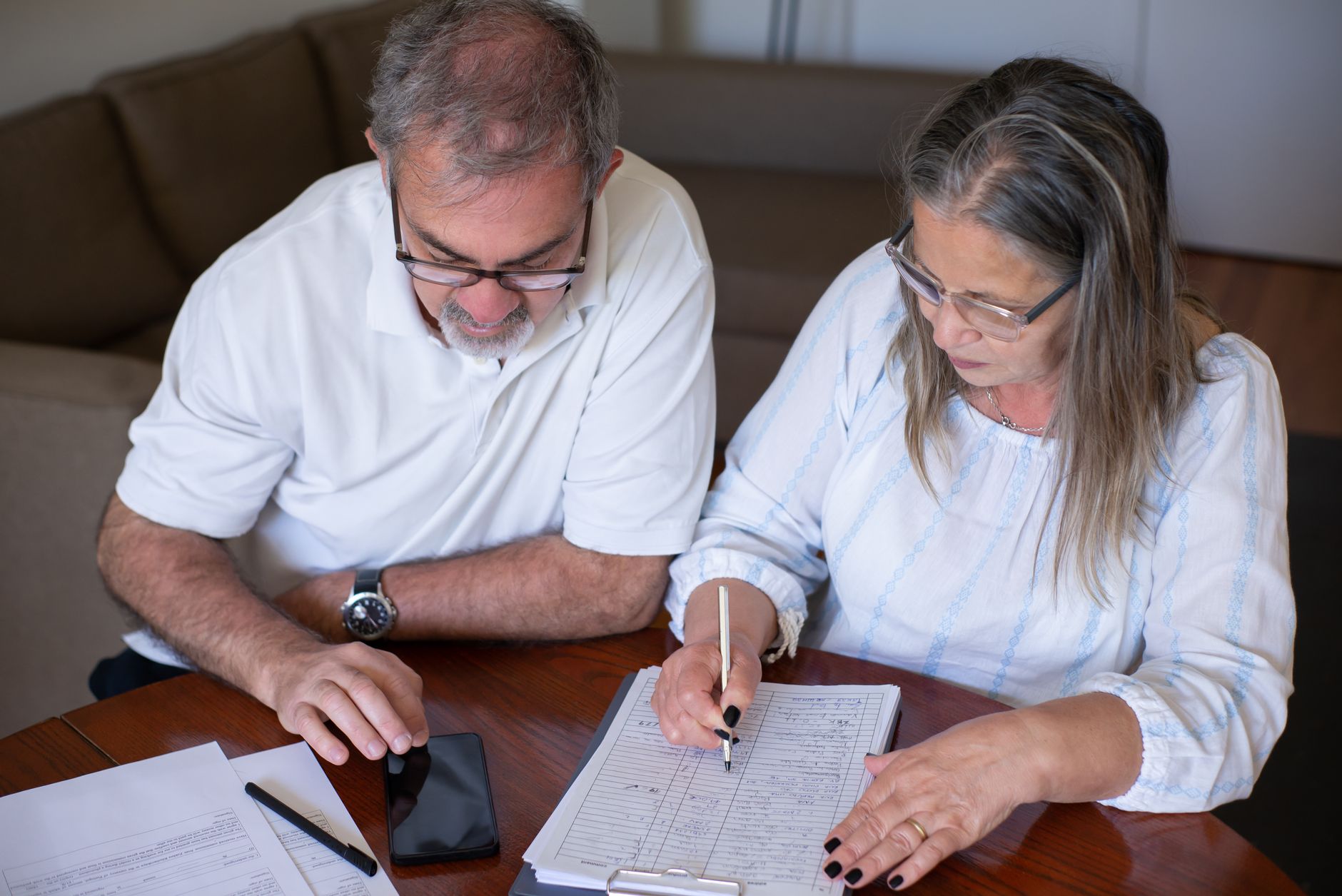 Retired couple reviewing financial documents at a table