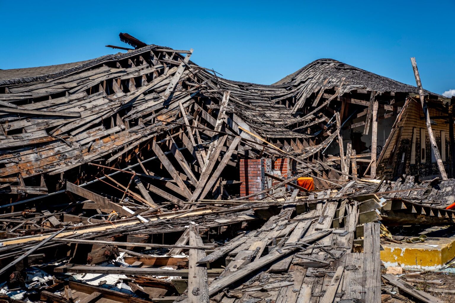 Homeowners Now Absorb Roof Costs Insurers Once Covered Close-up of a residential roof with visible storm and hail damage