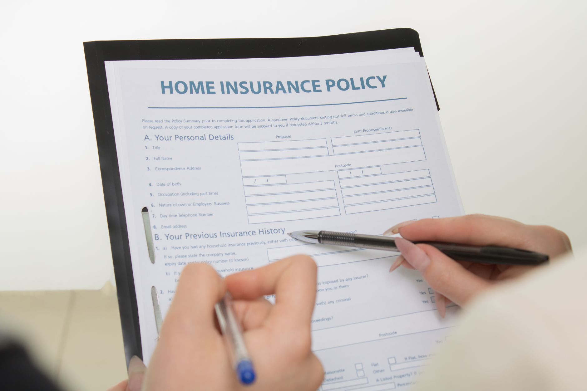 Homeowner reviewing insurance documents at a kitchen table