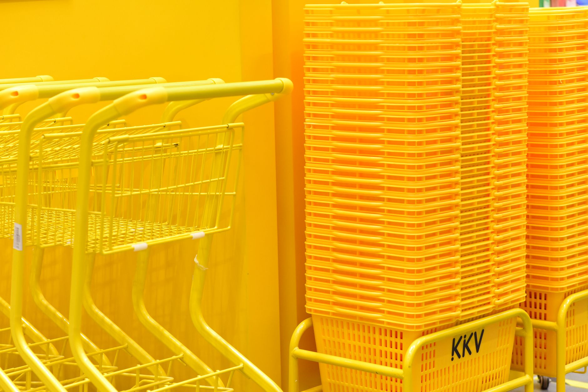 Consumer pushing a shopping cart through a supermarket aisle