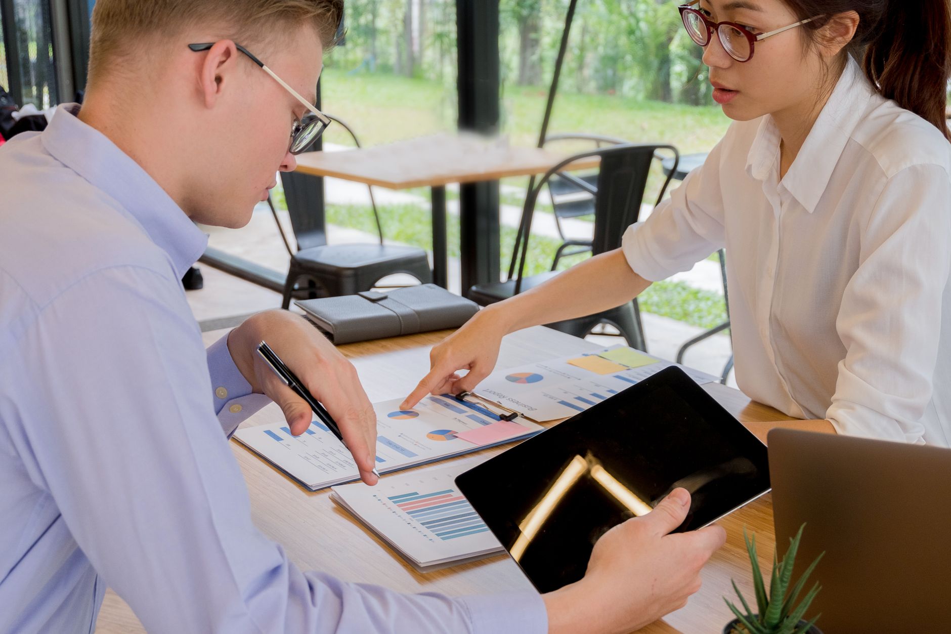 Business professionals reviewing investment implications of a corporate policy decision